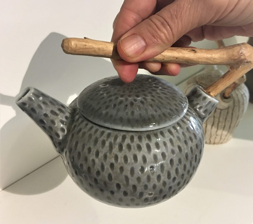 Small teapot with spots and wooden handle